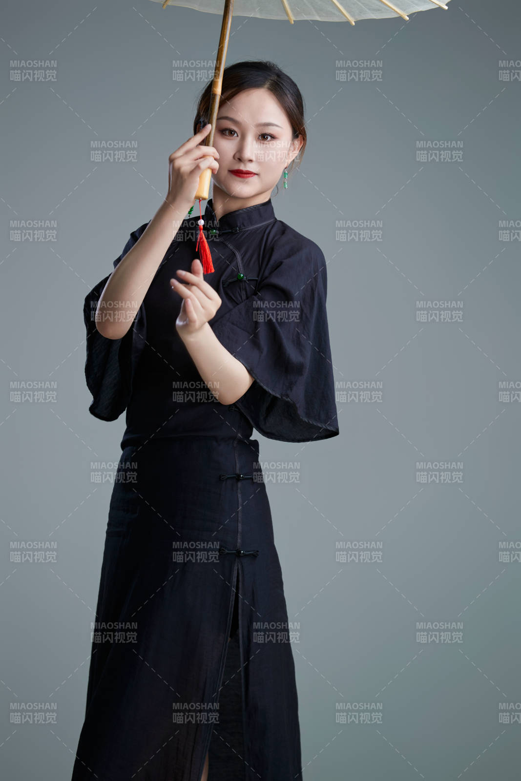 穿中式旗袍手拿油紙傘翩翩舞蹈的亞洲少女舞者