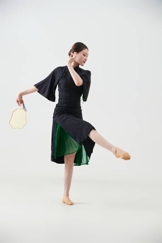 穿着中式旗袍翩翩舞蹈的亚洲少女舞者