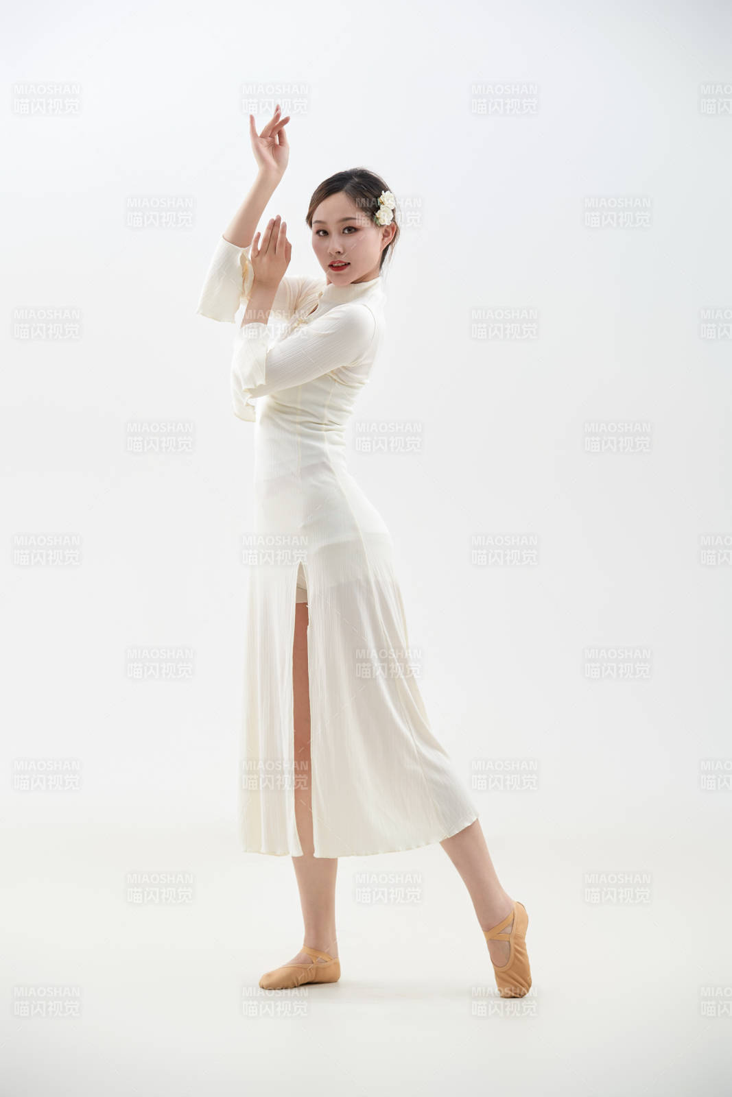 穿著白色旗袍頭戴絹花的跳古典舞的少女