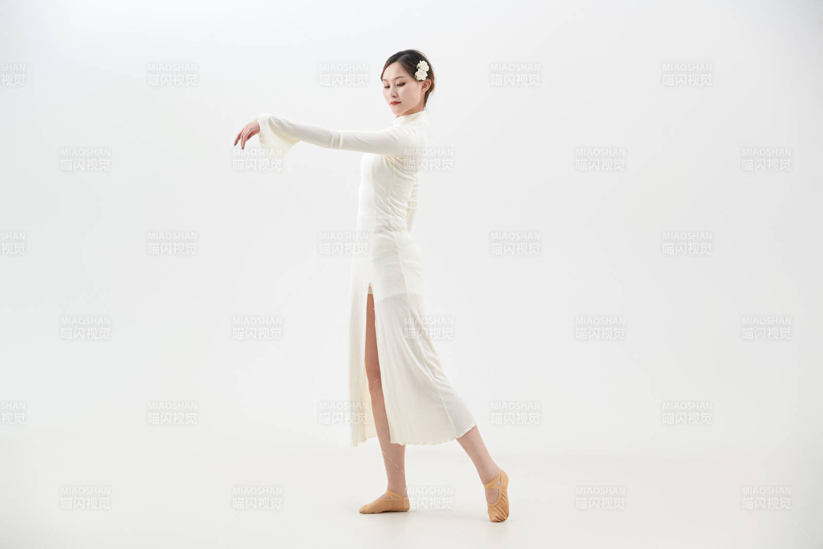 穿着白色旗袍头戴绢花的跳古典舞的少女