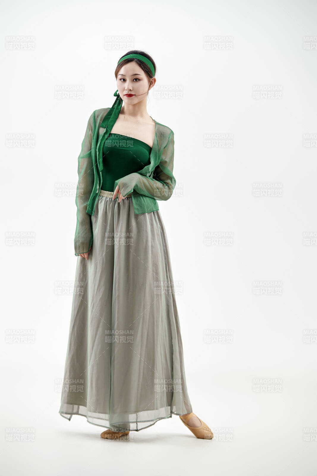 身穿青色古典舞蹈服裝手拿蒲扇跳舞的少女