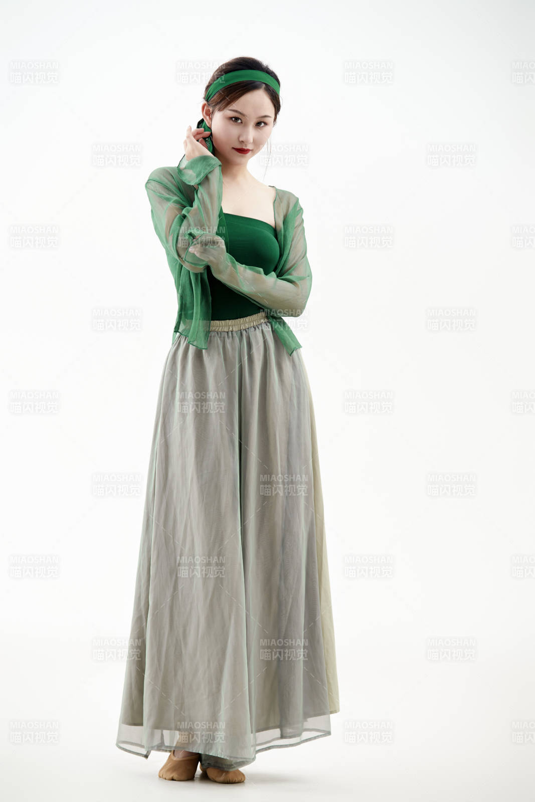 身穿青色古典舞蹈服裝手拿蒲扇跳舞的少女