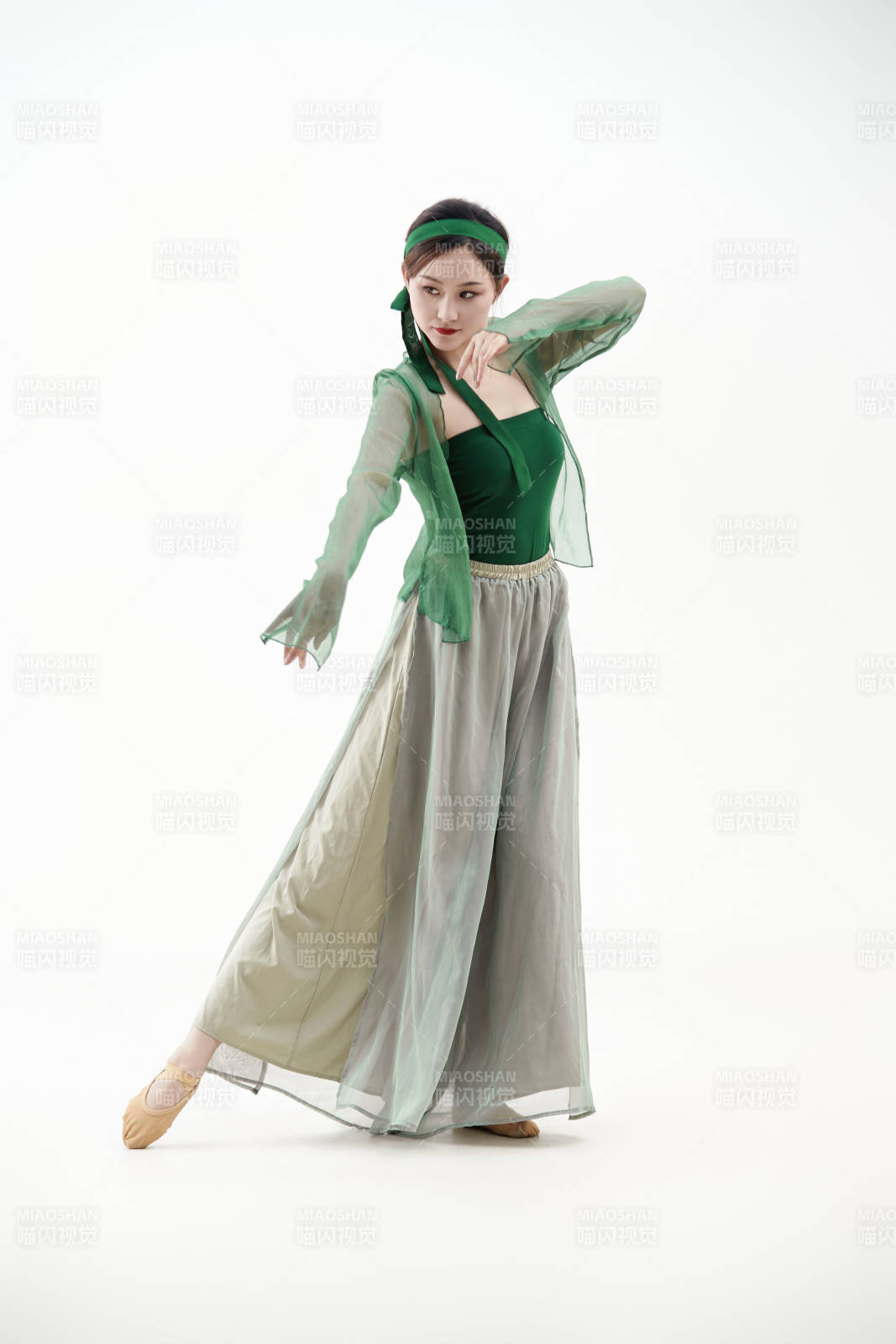 身穿青色古典舞蹈服裝手拿蒲扇跳舞的少女