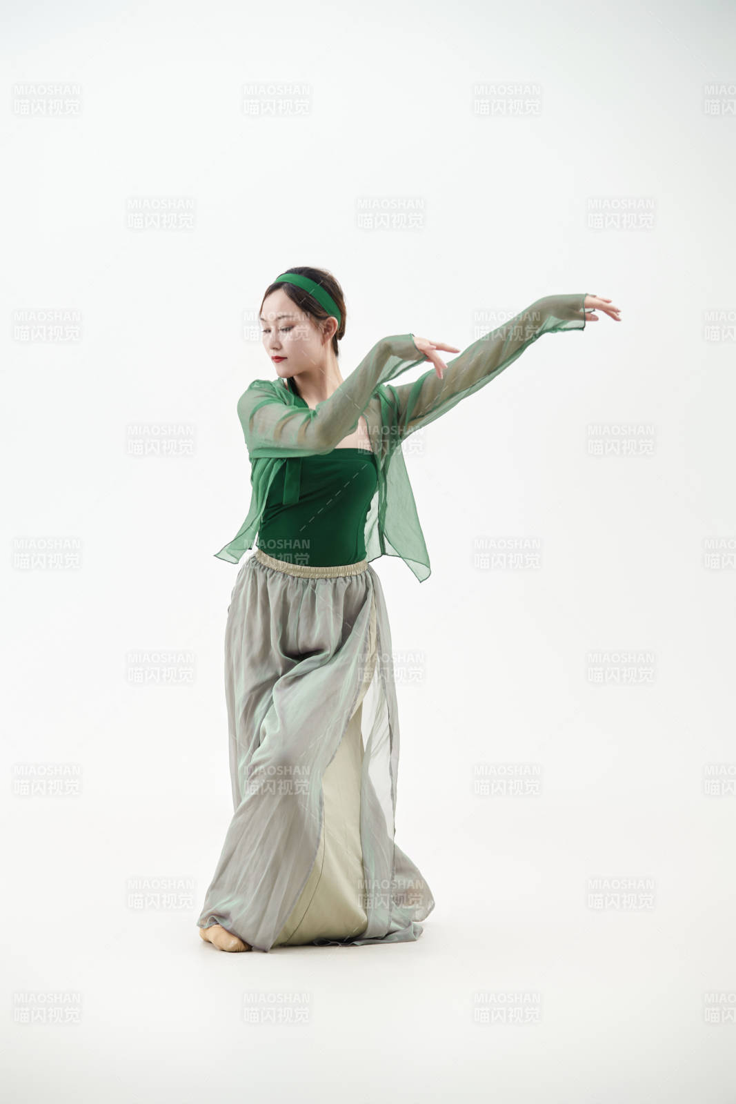 身穿青色古典舞蹈服裝手拿蒲扇跳舞的少女