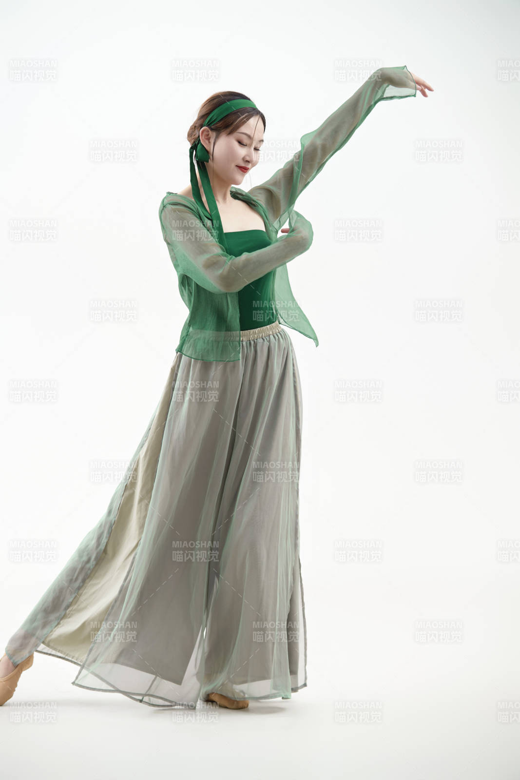 身穿青色古典舞蹈服裝手拿蒲扇跳舞的少女