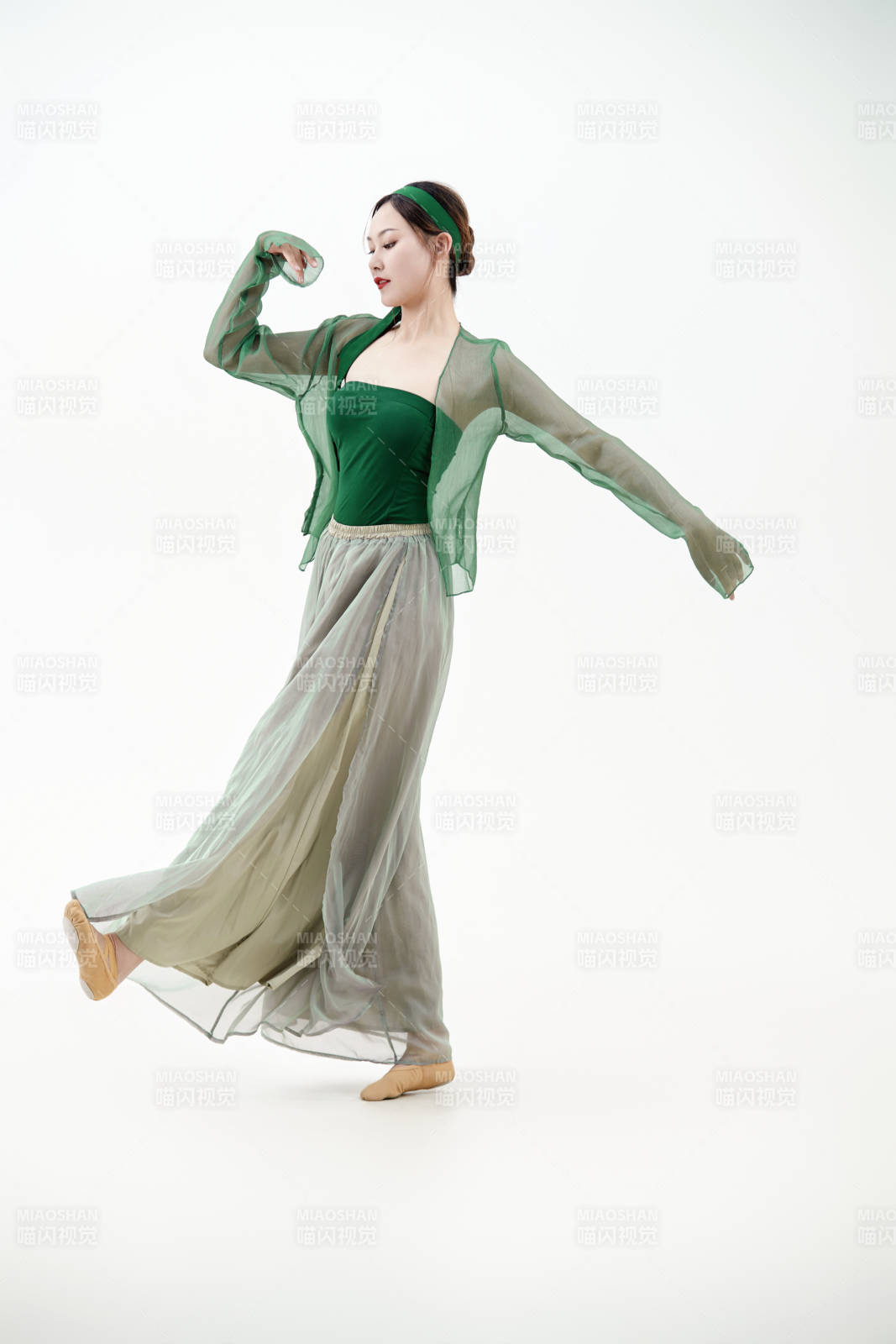 身穿青色古典舞蹈服裝手拿蒲扇跳舞的少女