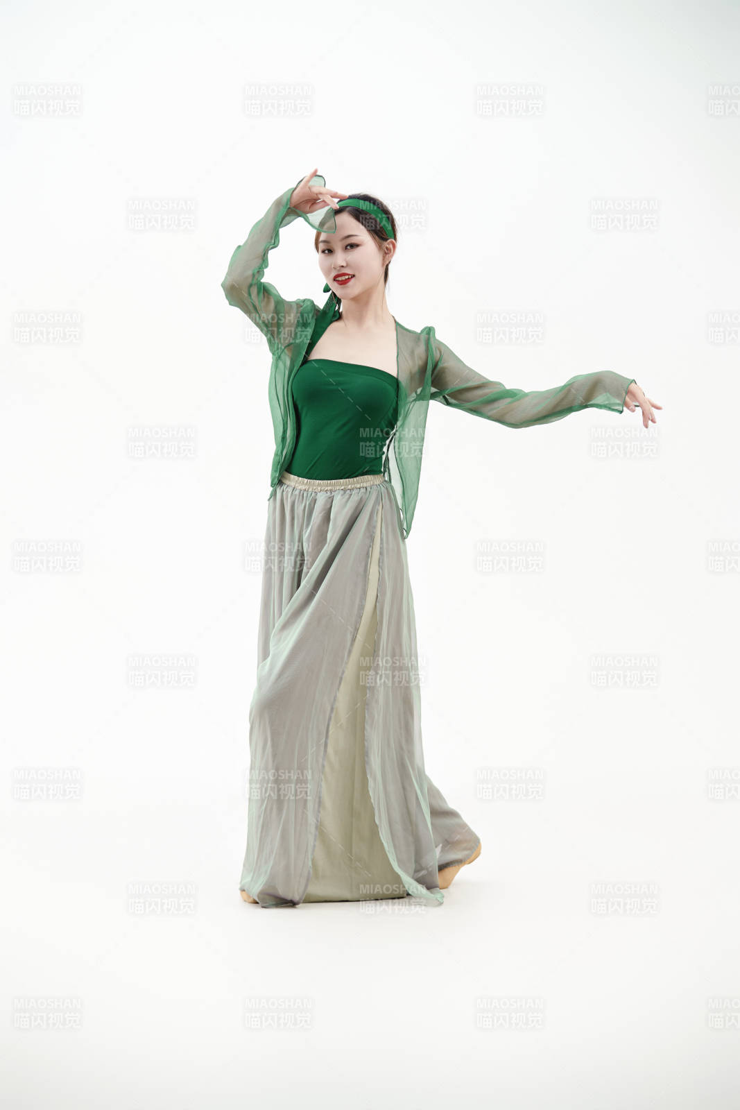 身穿青色古典舞蹈服裝手拿蒲扇跳舞的少女