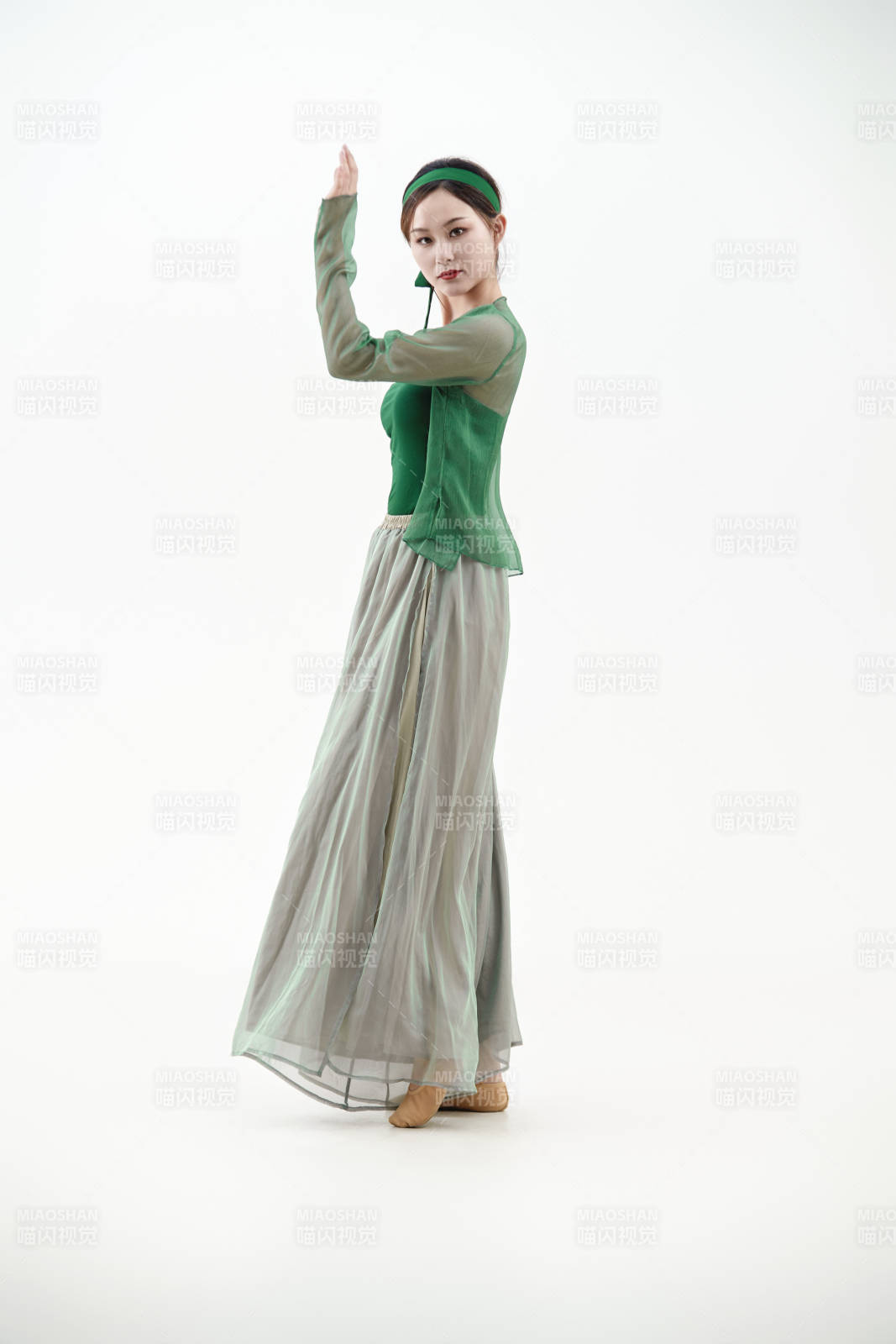 身穿青色古典舞蹈服裝手拿蒲扇跳舞的少女