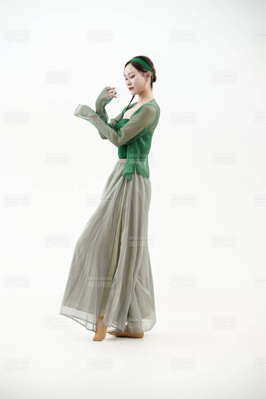 身穿青色古典舞蹈服裝手拿蒲扇跳舞的少女