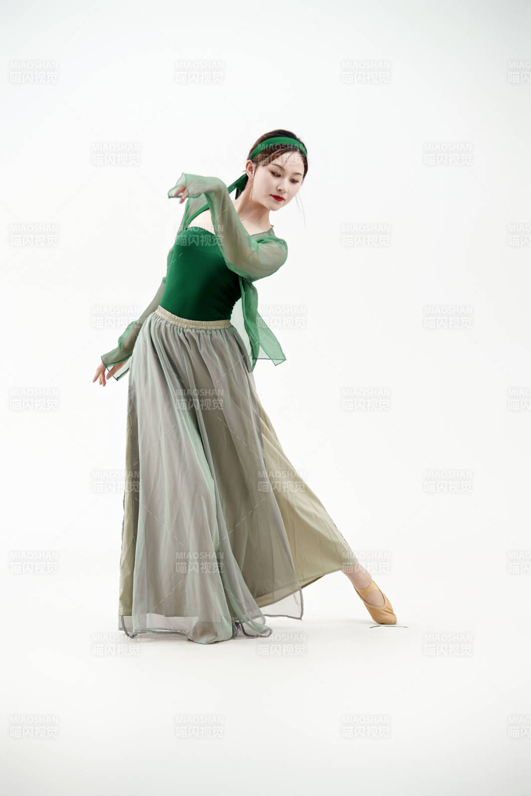 身穿青色古典舞蹈服裝手拿蒲扇跳舞的少女