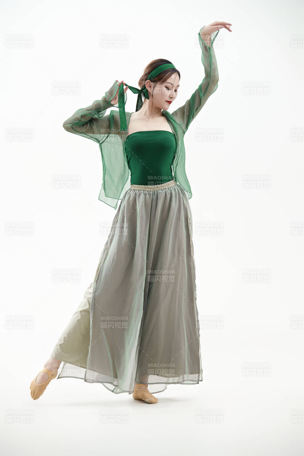 身穿青色古典舞蹈服裝手拿蒲扇跳舞的少女