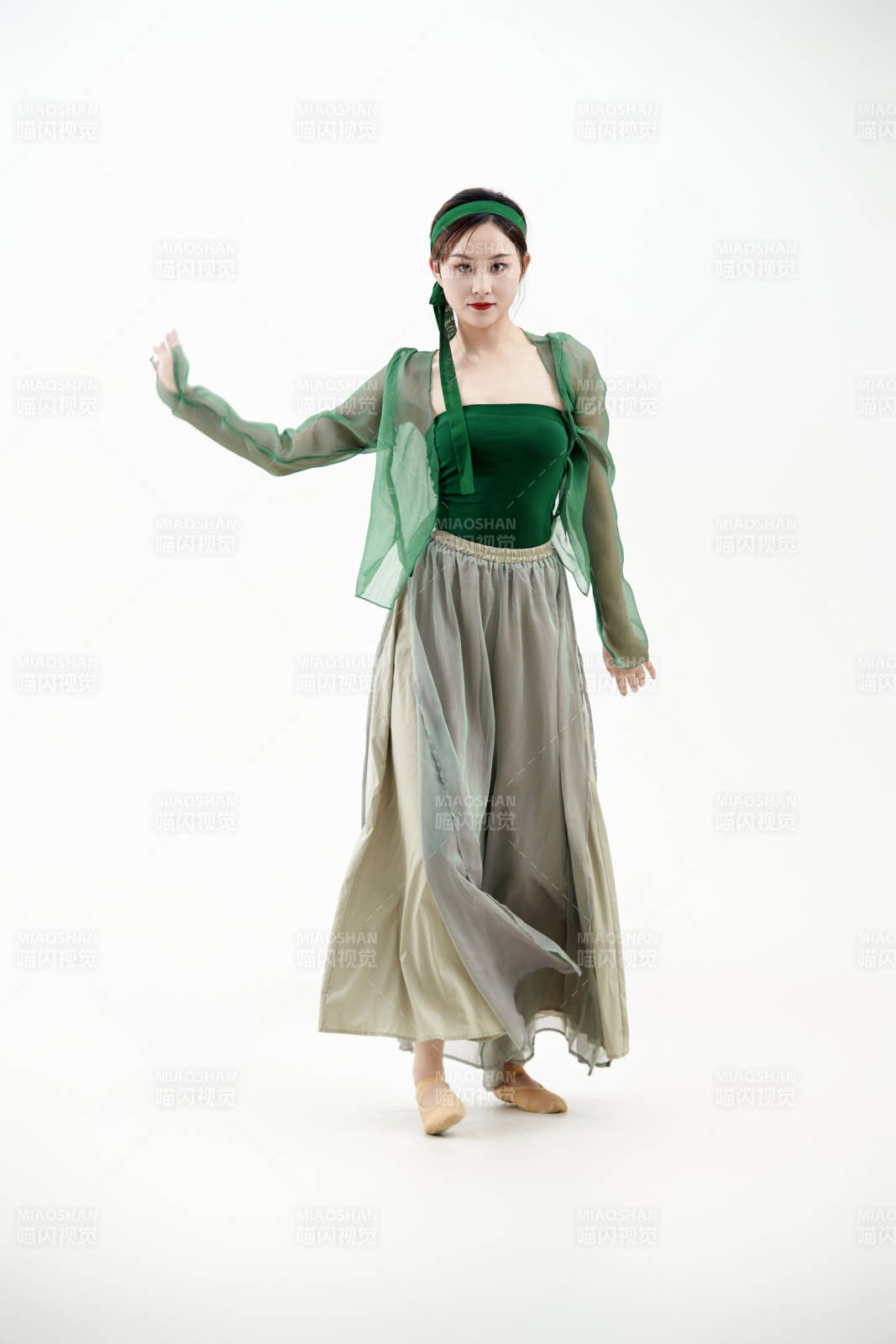 身穿青色古典舞蹈服裝手拿蒲扇跳舞的少女