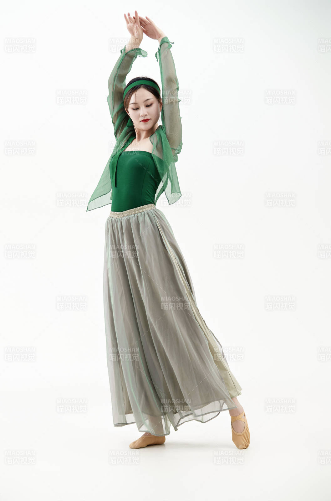 身穿青色古典舞蹈服裝手拿蒲扇跳舞的少女