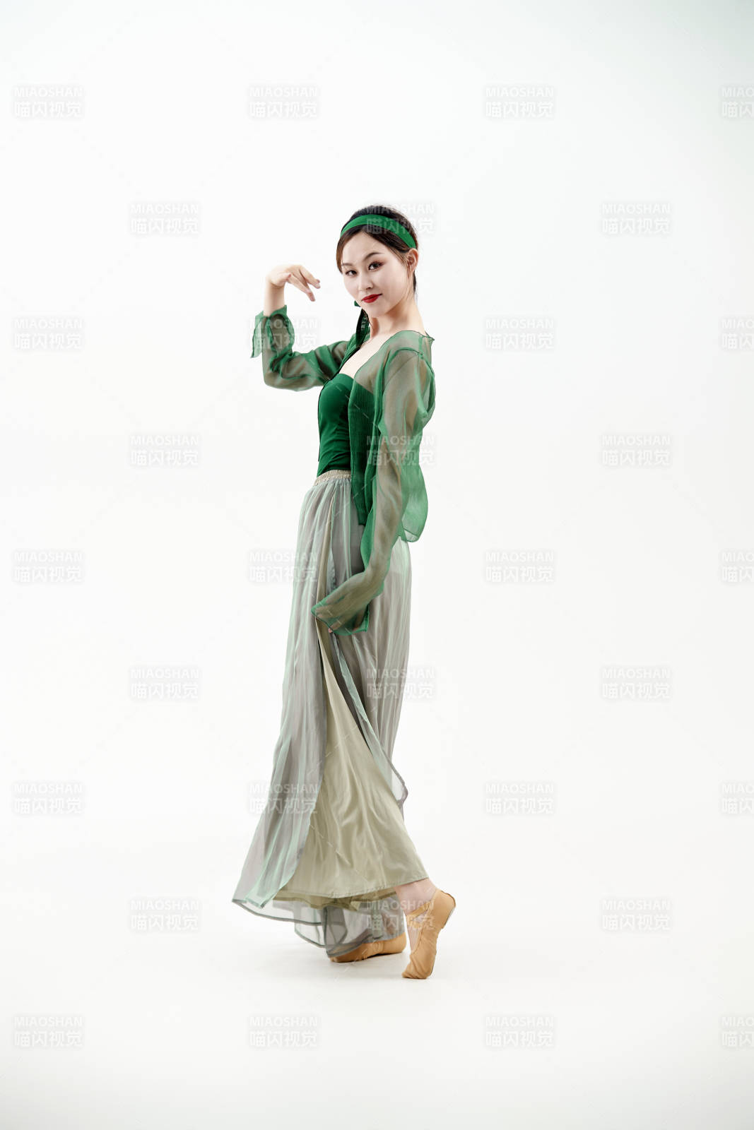 身穿青色古典舞蹈服裝手拿蒲扇跳舞的少女