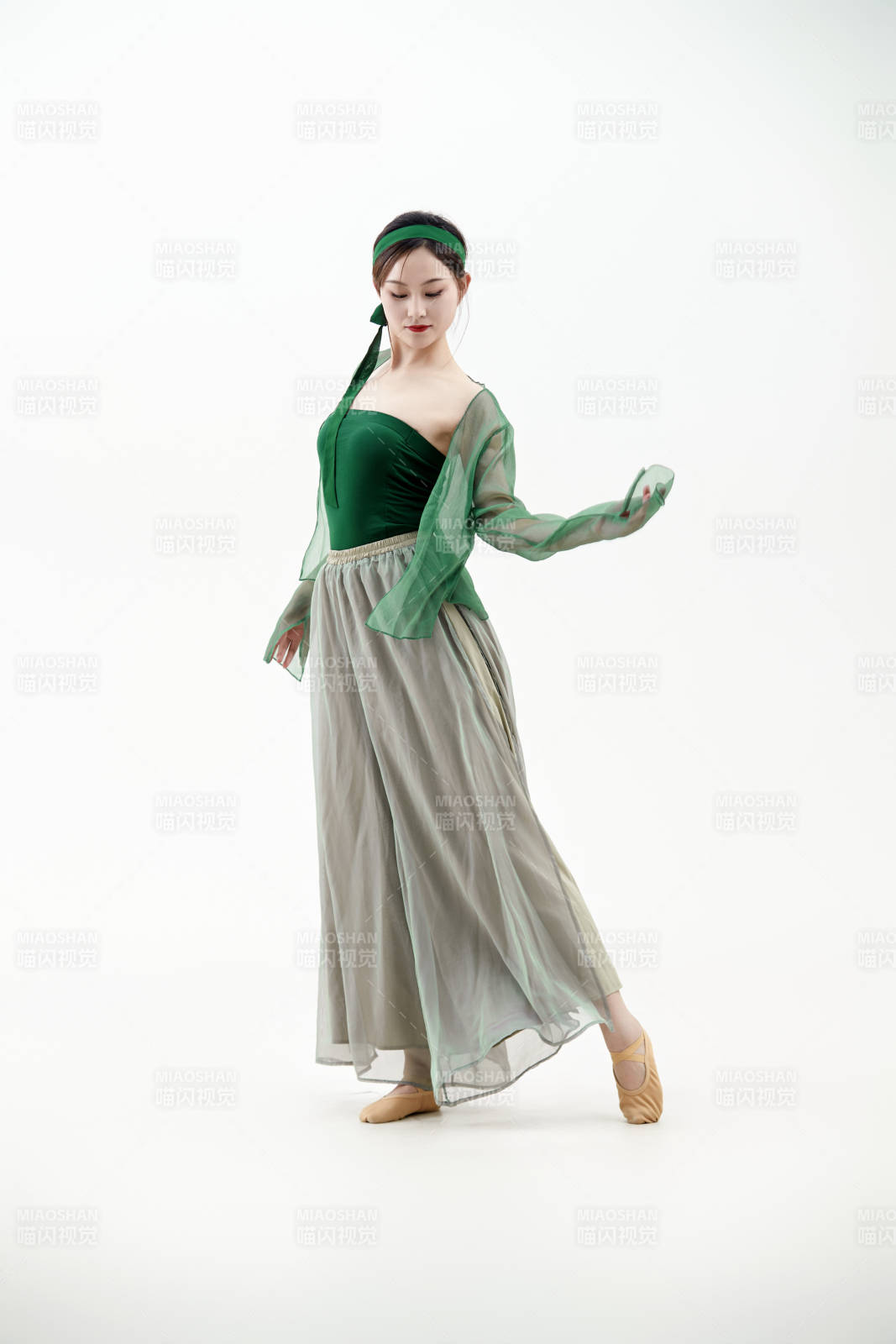 身穿青色古典舞蹈服裝手拿蒲扇跳舞的少女