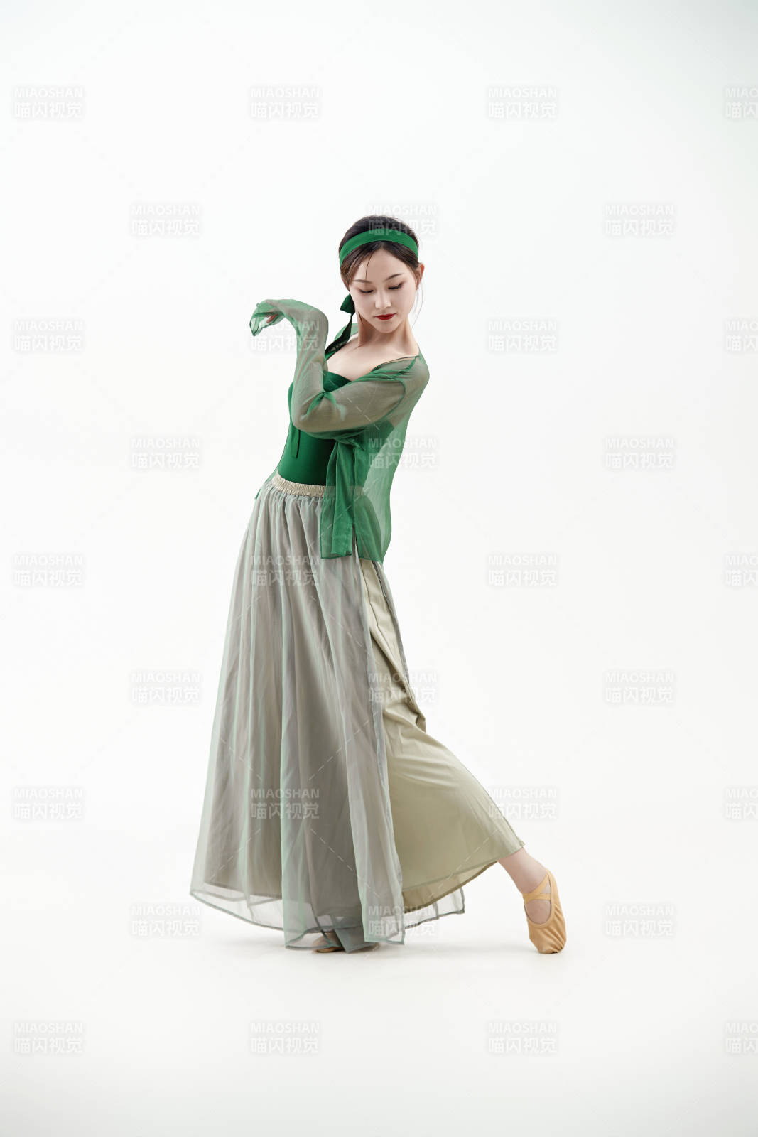 身穿青色古典舞蹈服裝手拿蒲扇跳舞的少女