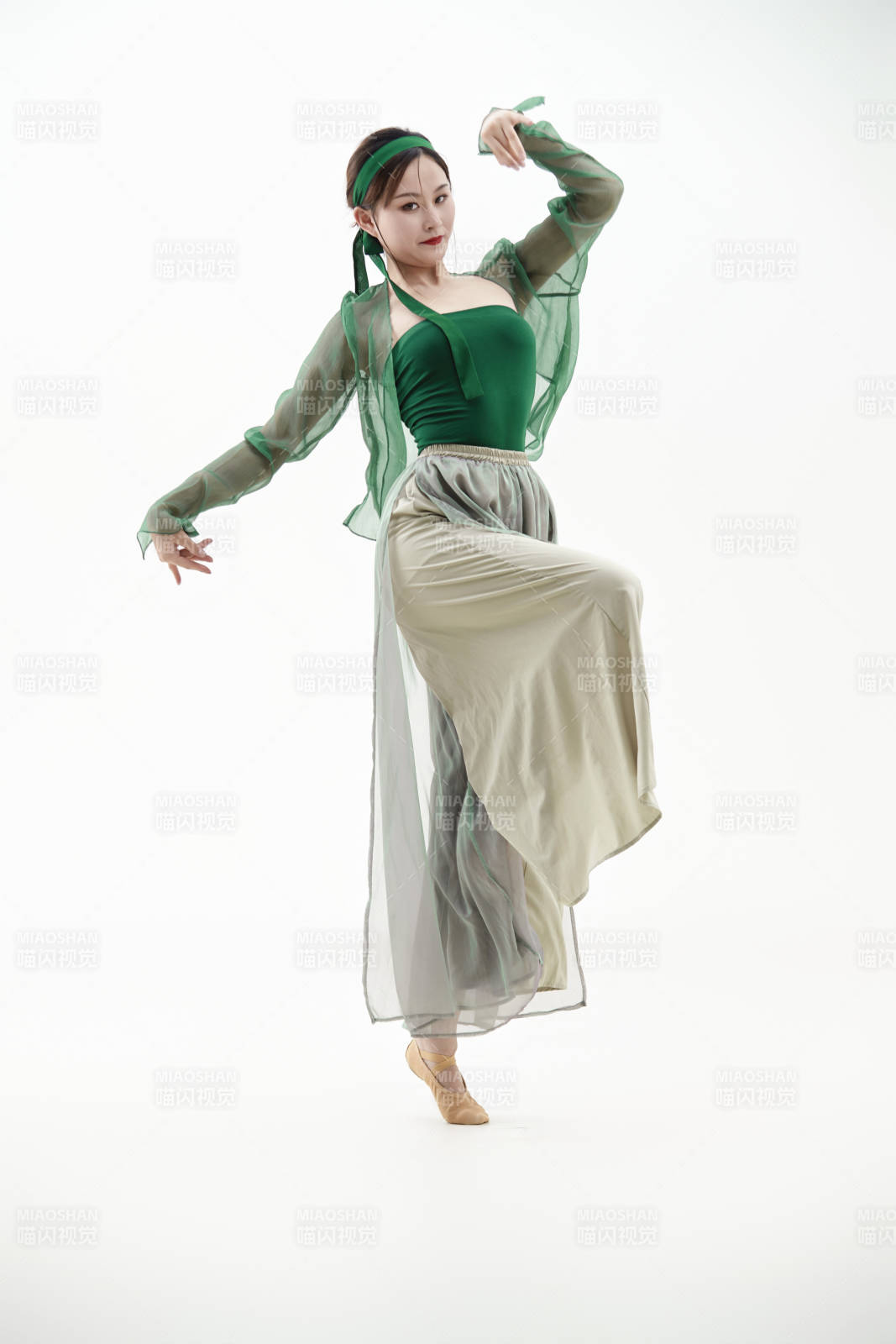 身穿青色古典舞蹈服裝手拿蒲扇跳舞的少女