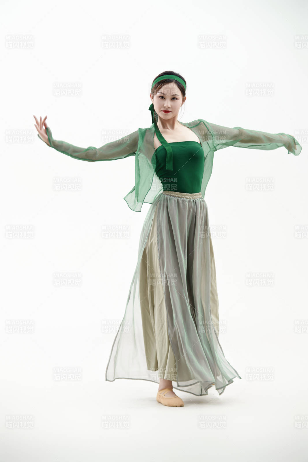 身穿青色古典舞蹈服裝手拿蒲扇跳舞的少女