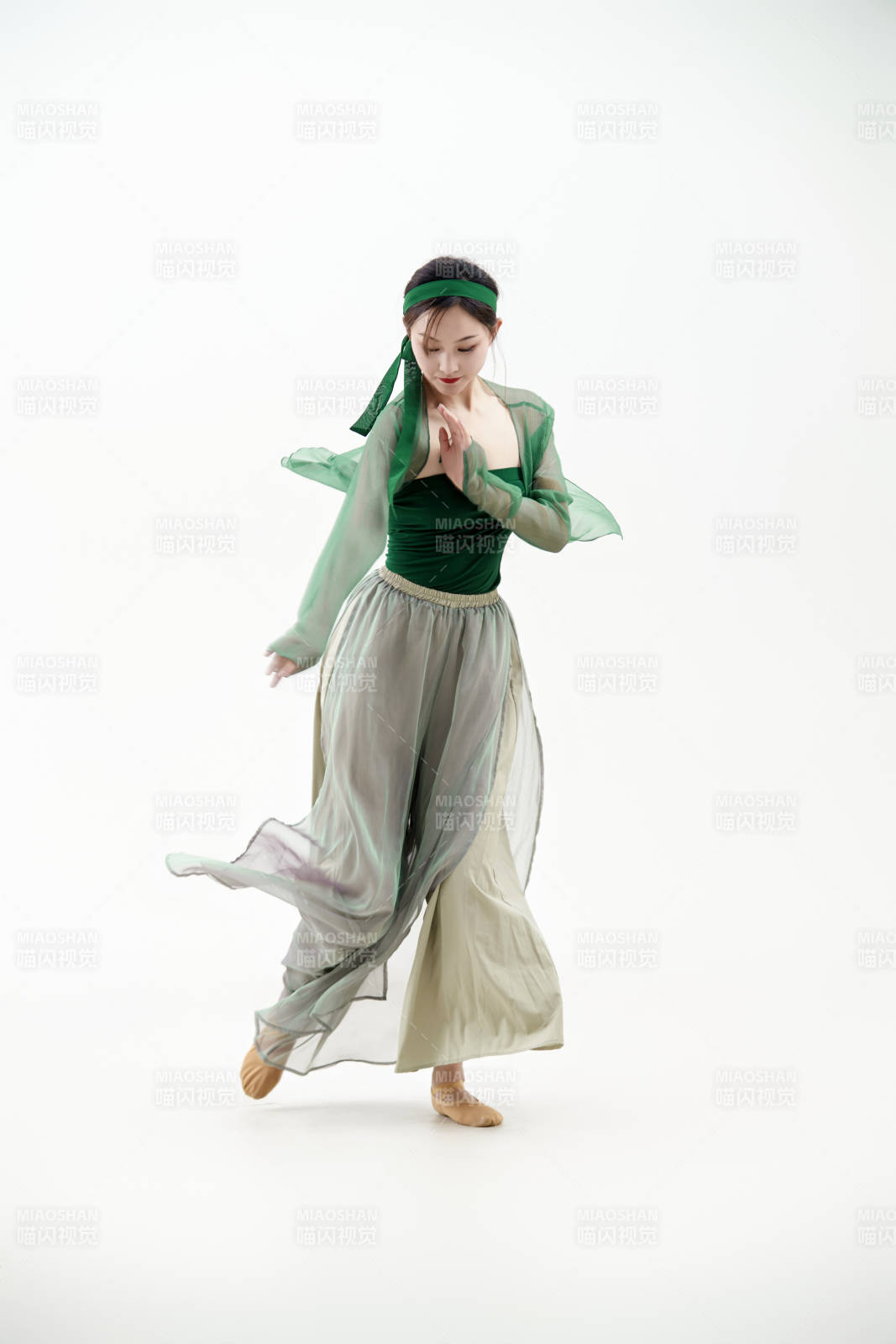 身穿青色古典舞蹈服裝手拿蒲扇跳舞的少女