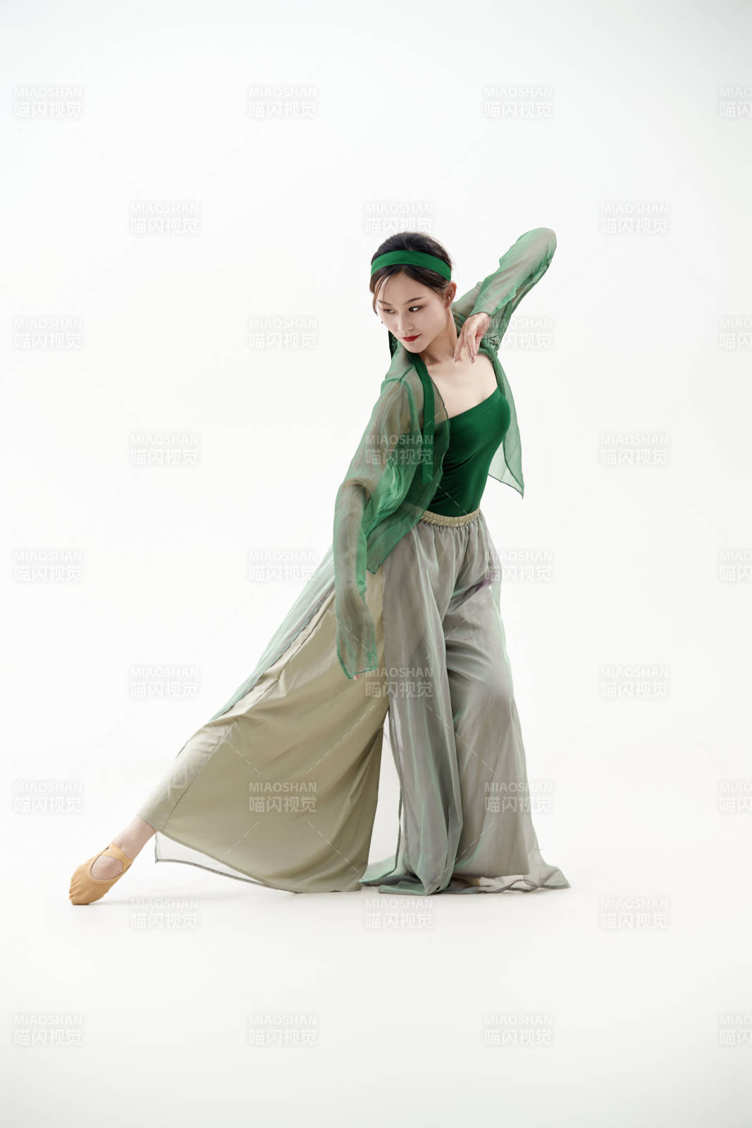 身穿青色古典舞蹈服裝手拿蒲扇跳舞的少女