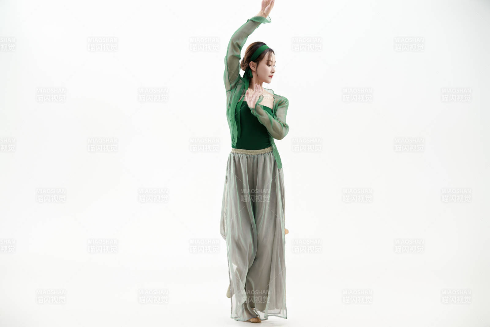 身穿青色古典舞蹈服裝手拿蒲扇跳舞的少女