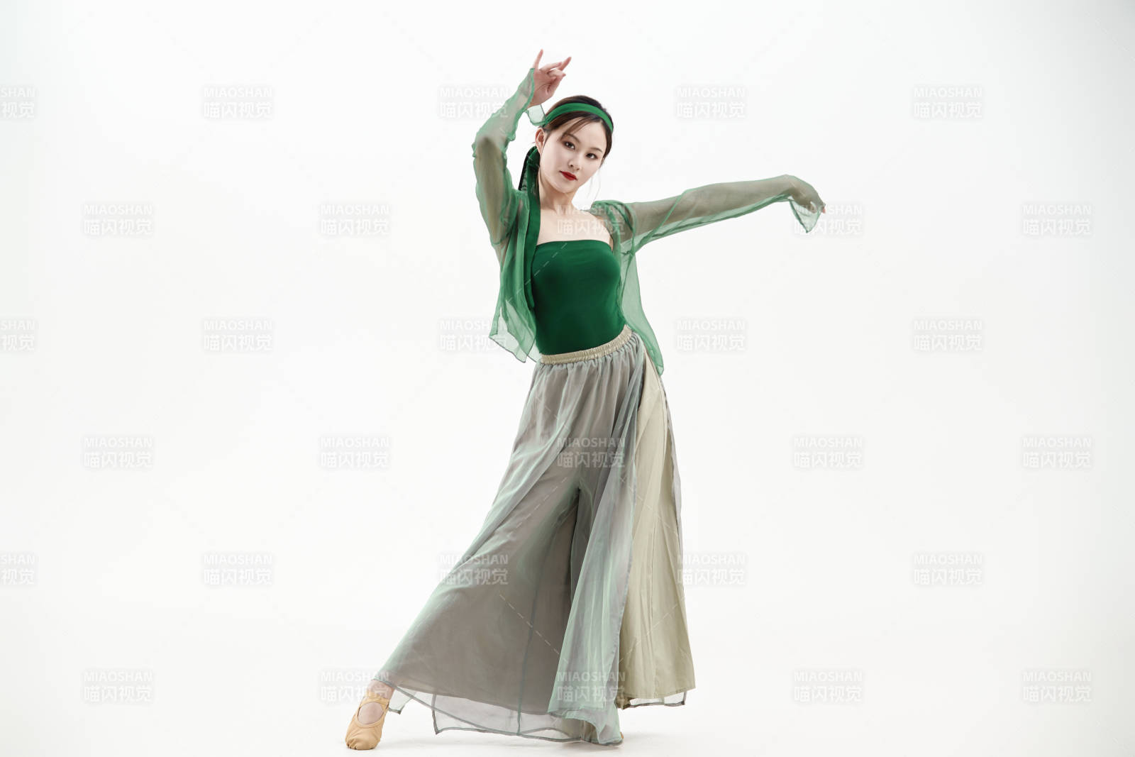 身穿青色古典舞蹈服裝手拿蒲扇跳舞的少女