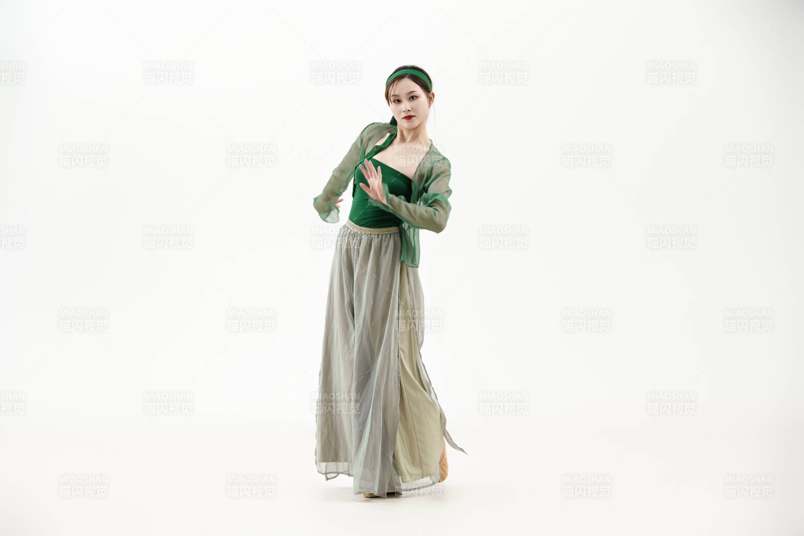 身穿青色古典舞蹈服裝手拿蒲扇跳舞的少女