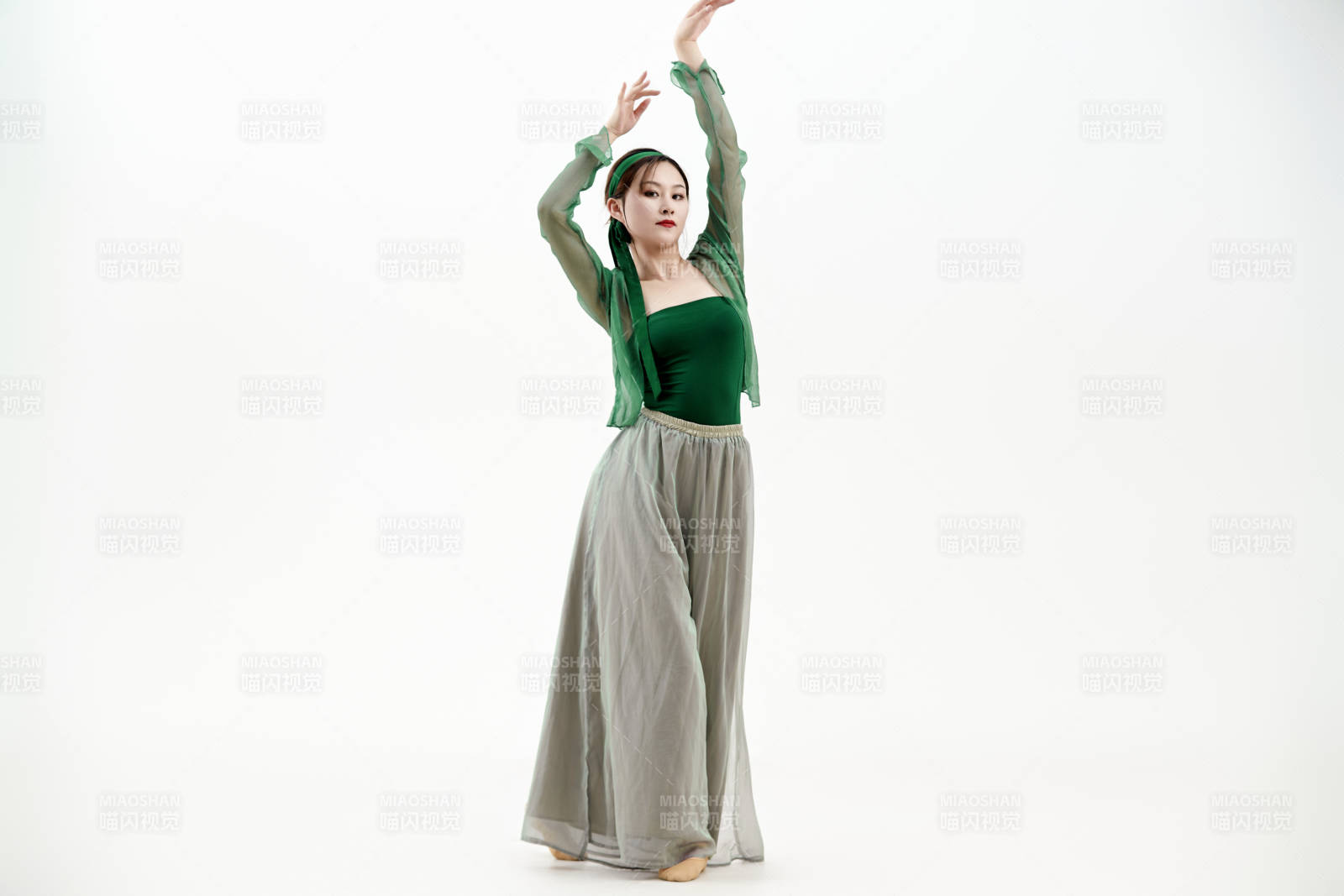 身穿青色古典舞蹈服裝手拿蒲扇跳舞的少女