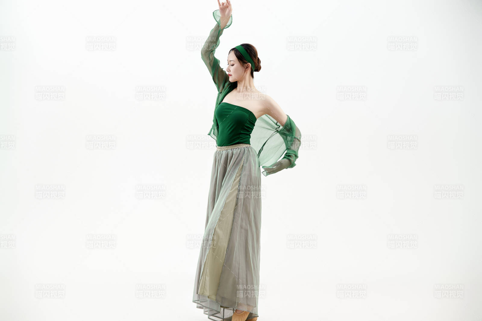 身穿青色古典舞蹈服裝手拿蒲扇跳舞的少女