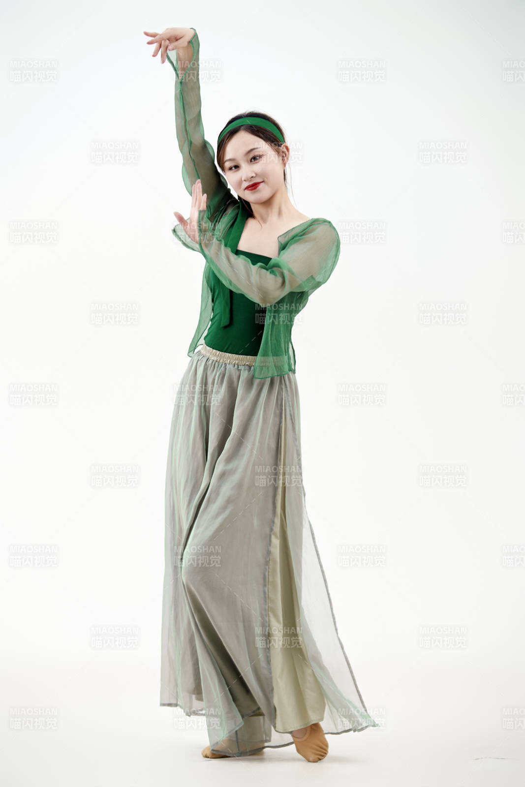 身穿青色古典舞蹈服裝手拿蒲扇跳舞的少女