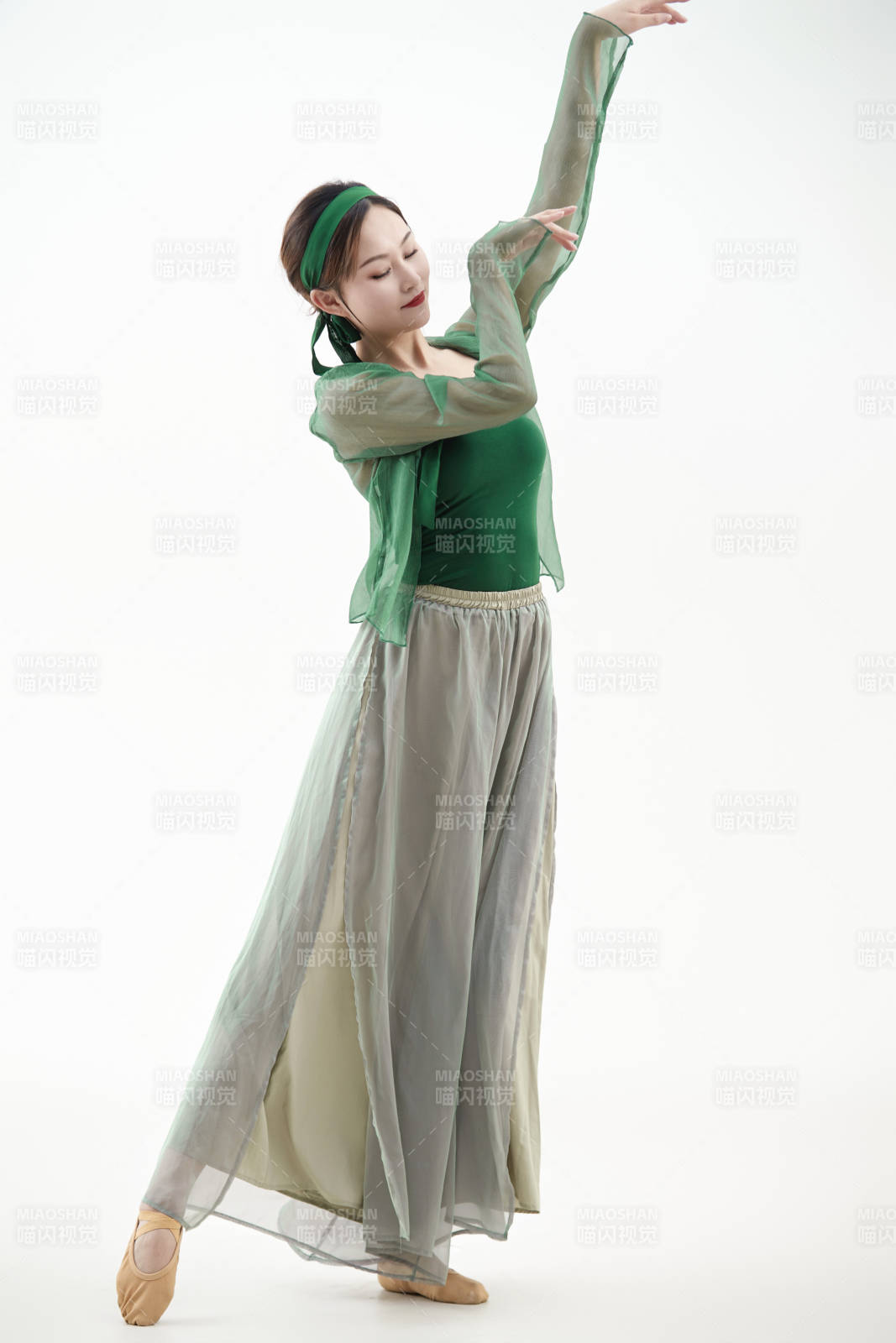 身穿青色古典舞蹈服裝手拿蒲扇跳舞的少女