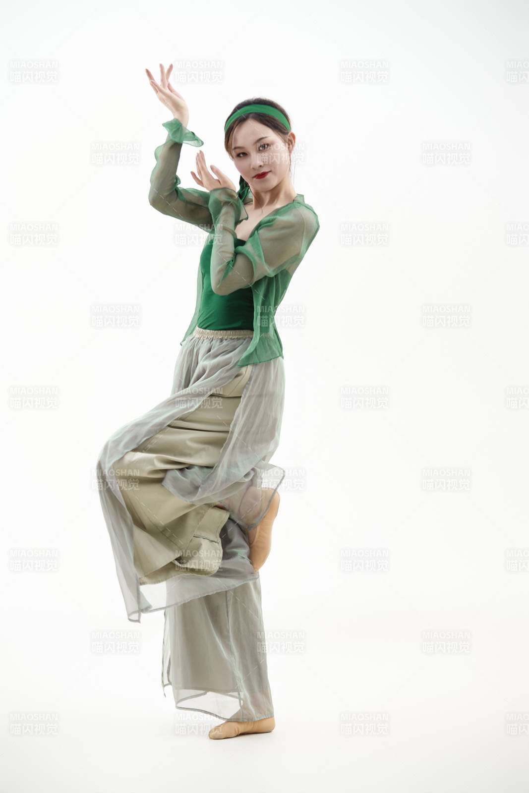 身穿青色古典舞蹈服裝手拿蒲扇跳舞的少女