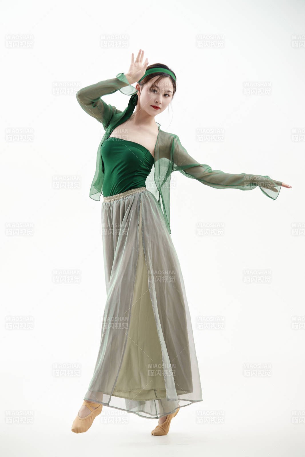 身穿青色古典舞蹈服裝手拿蒲扇跳舞的少女