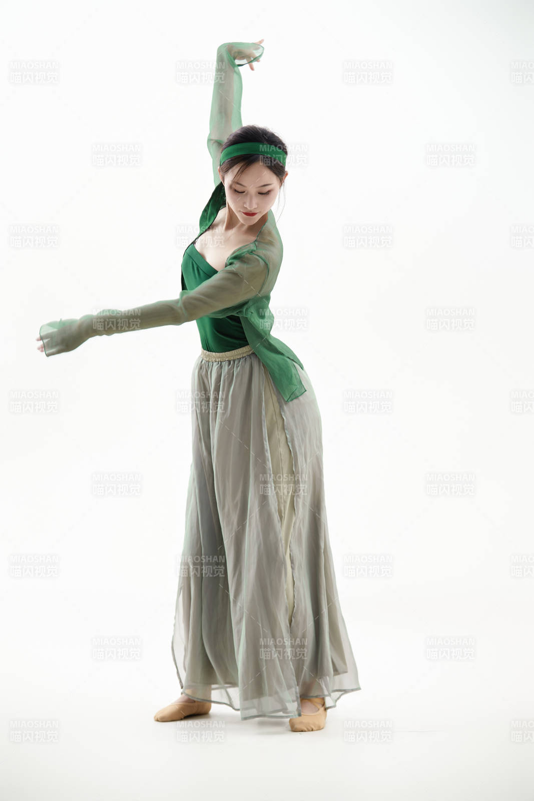 身穿青色古典舞蹈服裝手拿蒲扇跳舞的少女