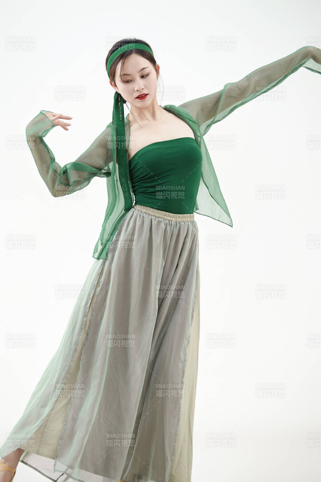 身穿青色古典舞蹈服裝手拿蒲扇跳舞的少女