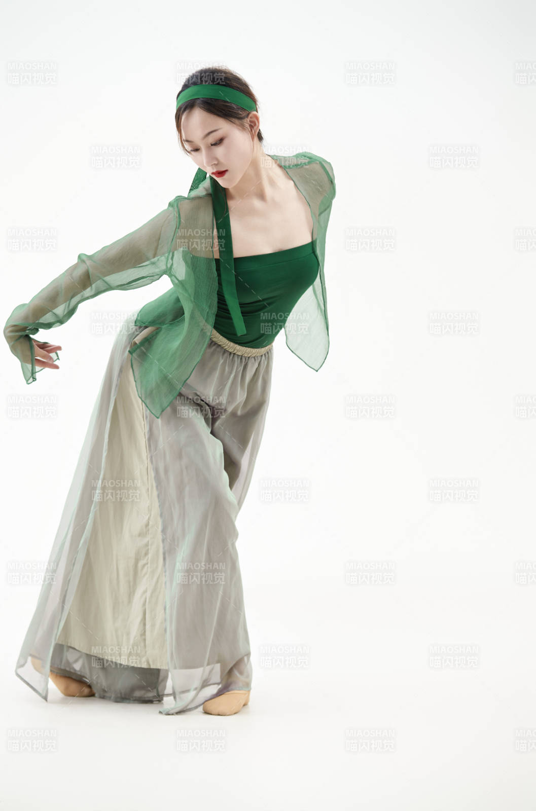 身穿青色古典舞蹈服裝手拿蒲扇跳舞的少女