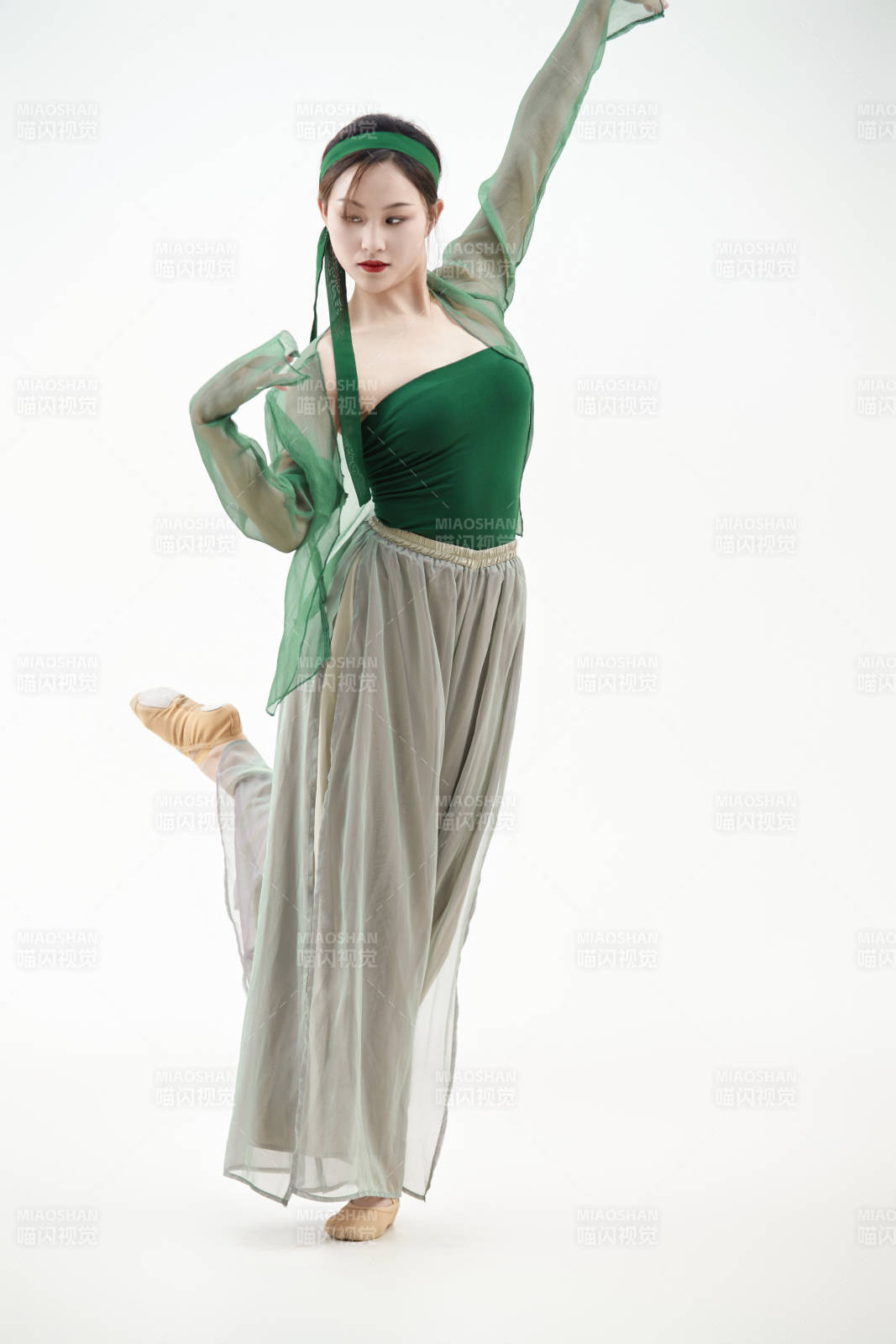 身穿青色古典舞蹈服裝手拿蒲扇跳舞的少女