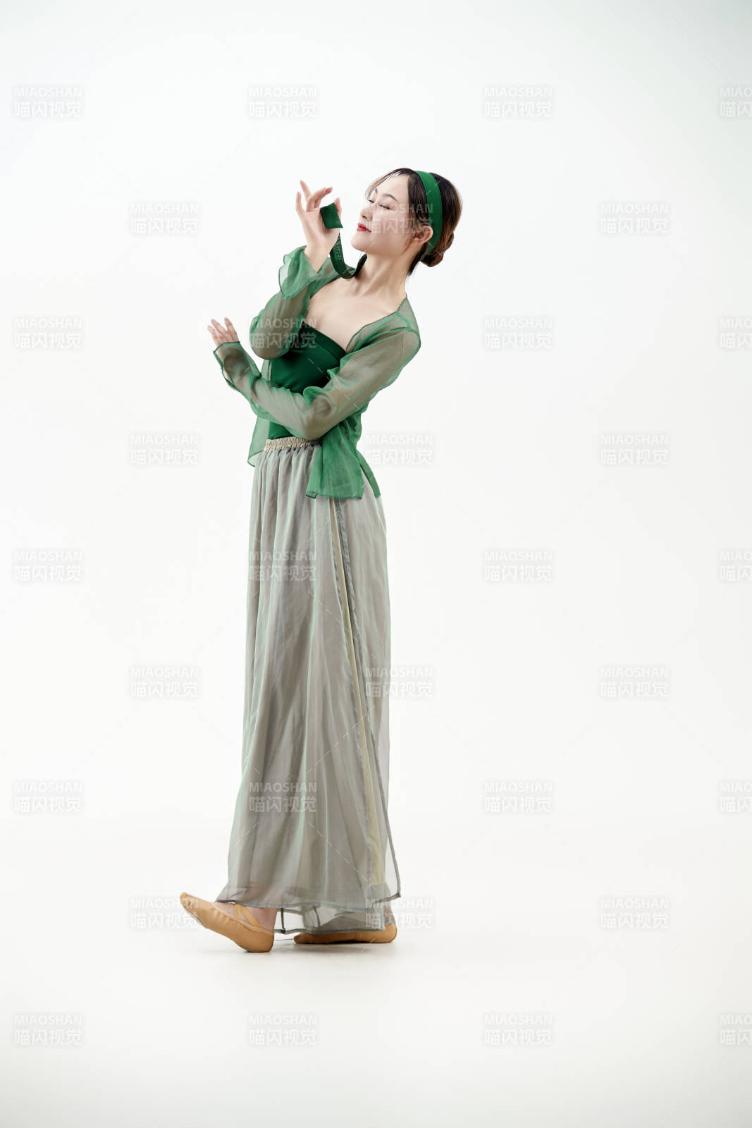 身穿青色古典舞蹈服裝手拿蒲扇跳舞的少女