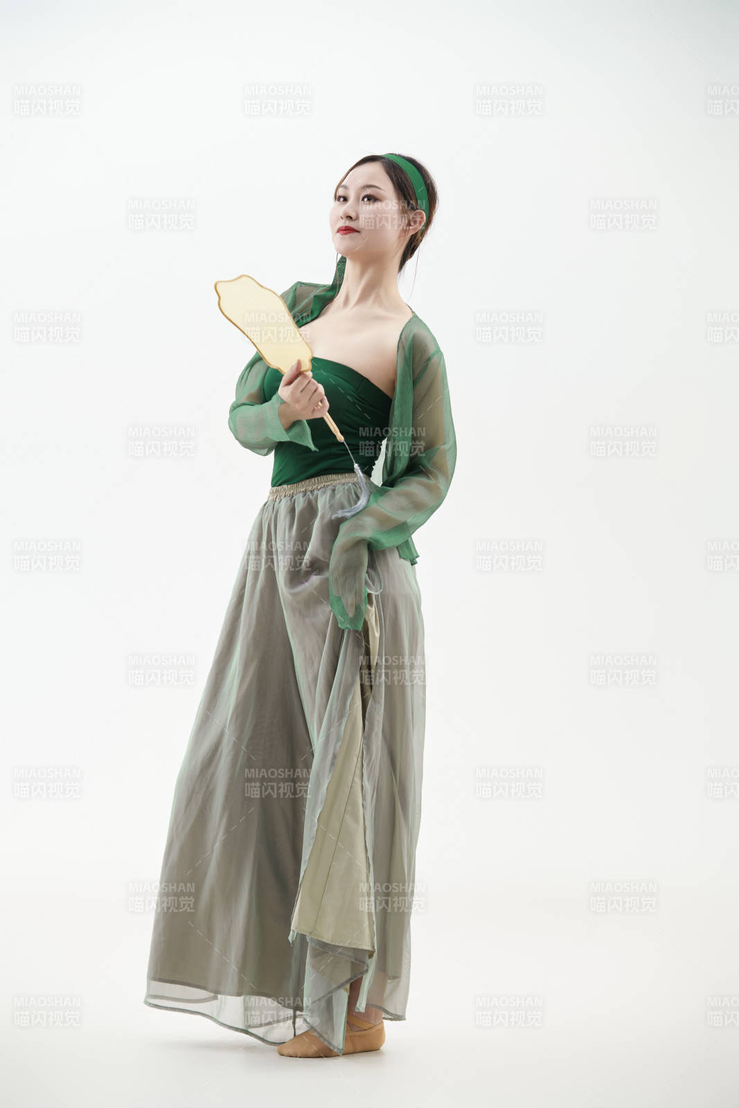 身穿青色古典舞蹈服裝手拿蒲扇跳舞的少女