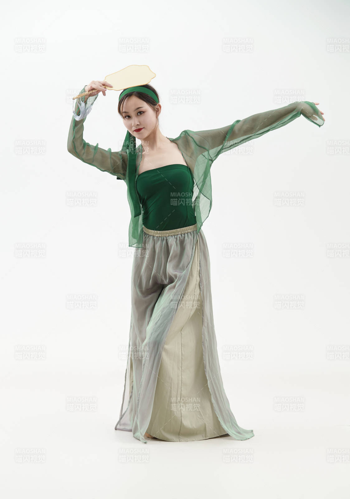 身穿青色古典舞蹈服裝手拿蒲扇跳舞的少女