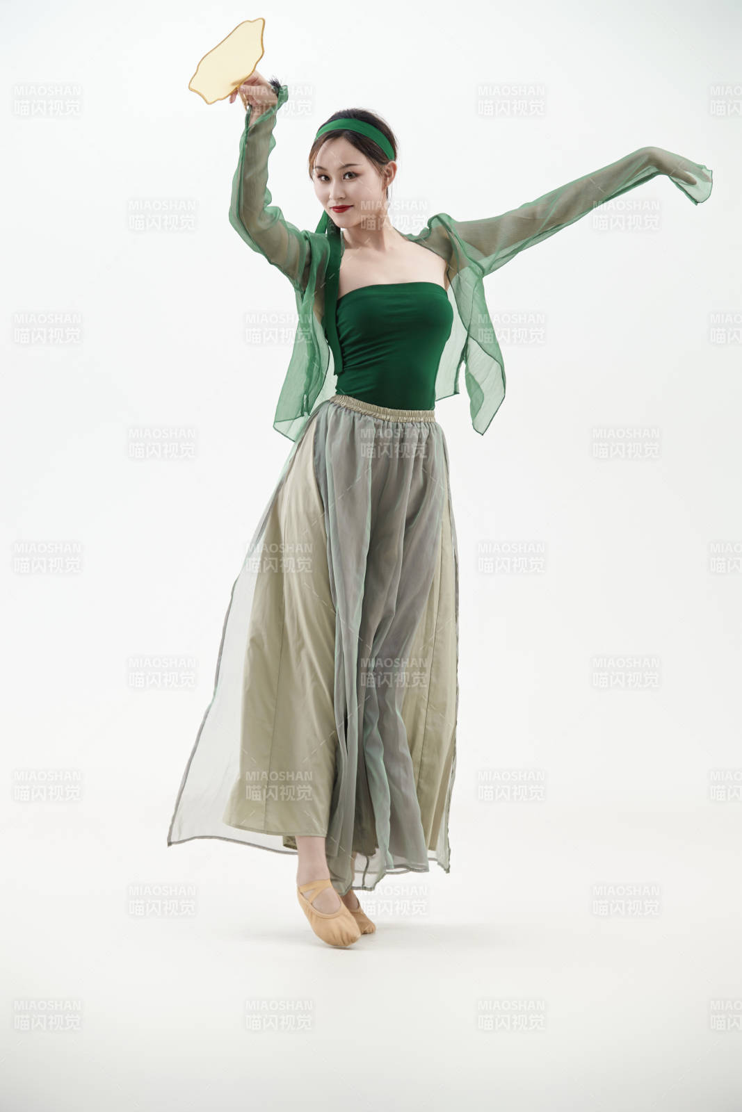 身穿青色古典舞蹈服裝手拿蒲扇跳舞的少女