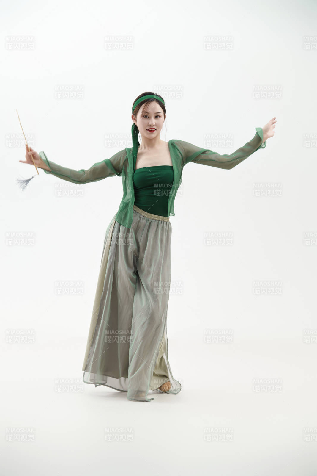 身穿青色古典舞蹈服裝手拿蒲扇跳舞的少女