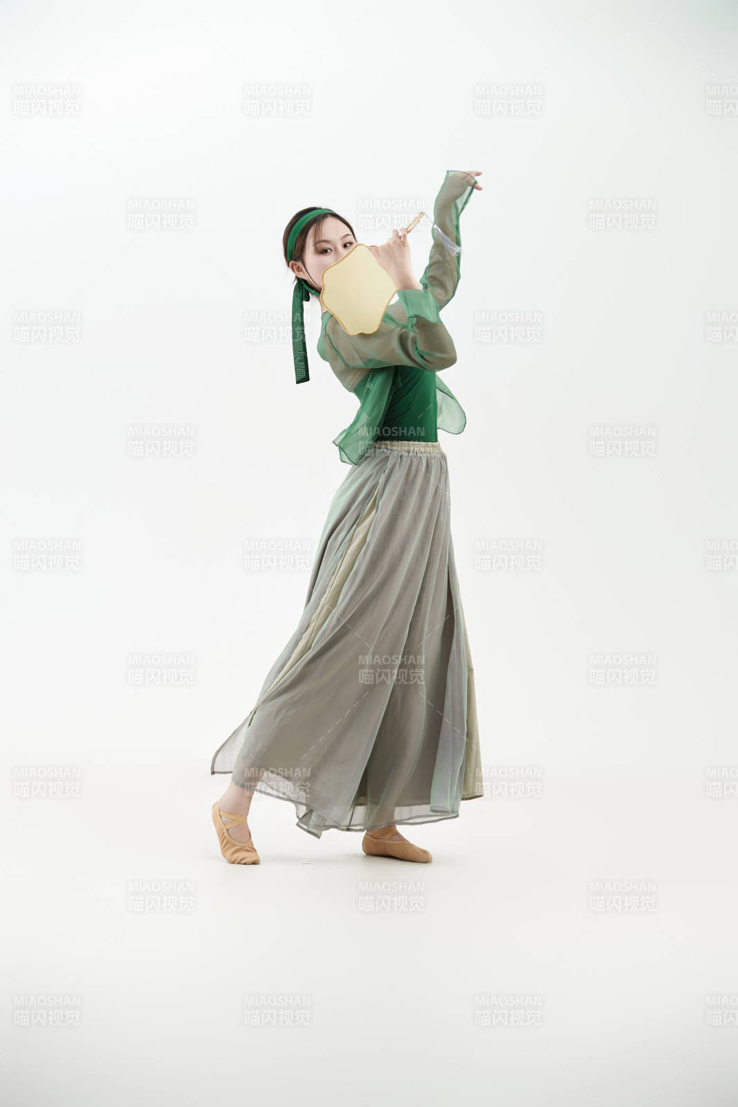 身穿青色古典舞蹈服裝手拿蒲扇跳舞的少女
