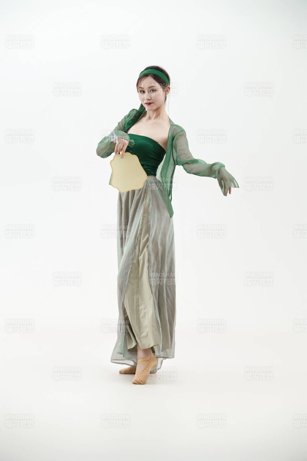 身穿青色古典舞蹈服裝手拿蒲扇跳舞的少女
