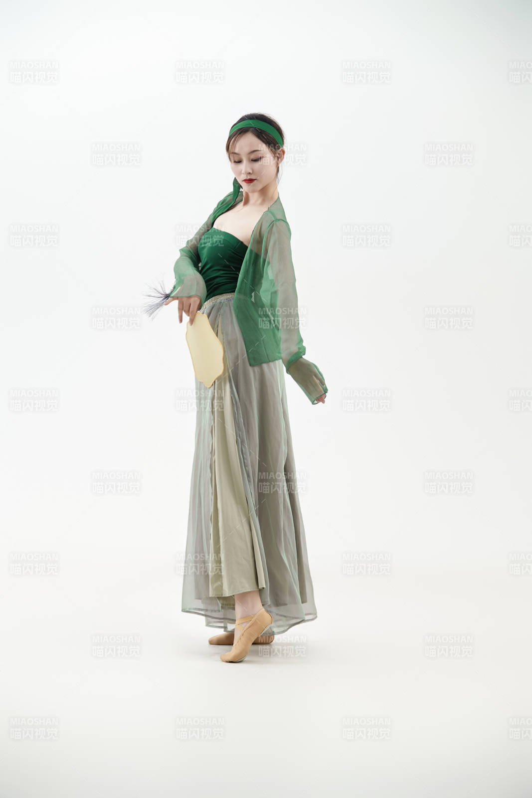 身穿青色古典舞蹈服裝手拿蒲扇跳舞的少女