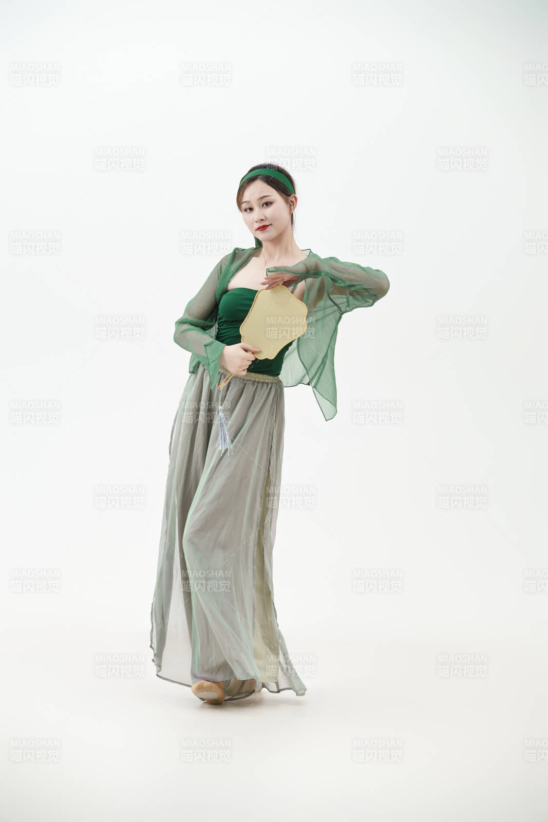 身穿青色古典舞蹈服裝手拿蒲扇跳舞的少女