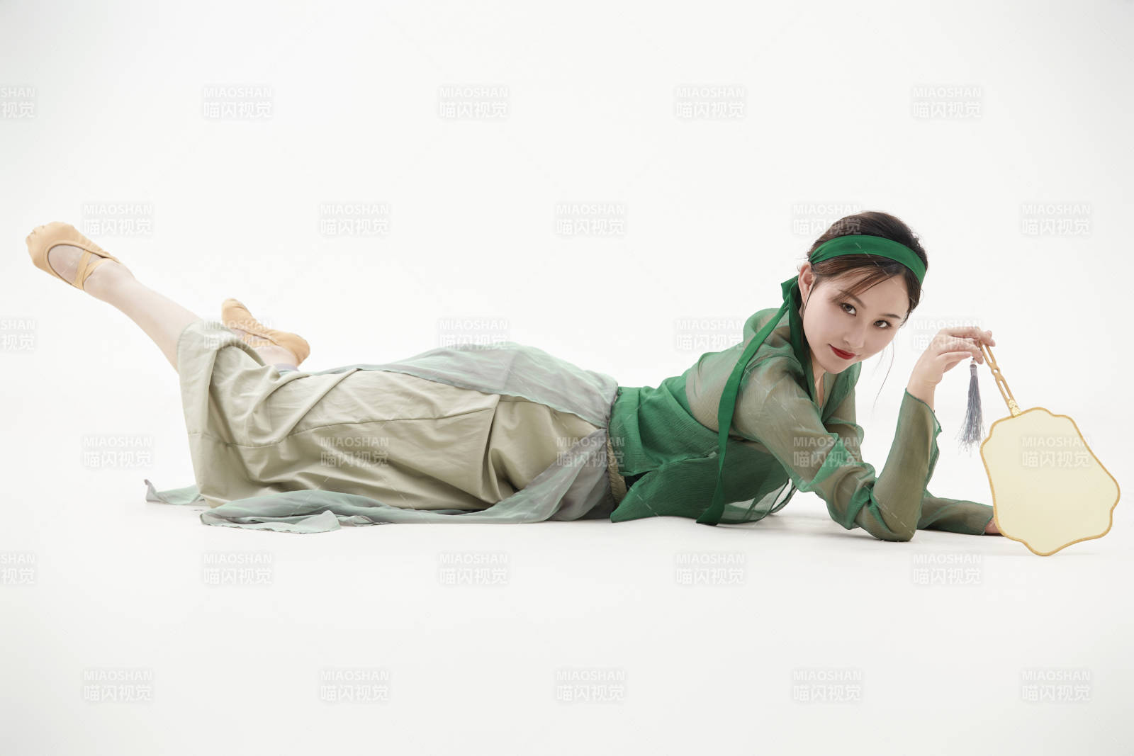 身穿青色古典舞蹈服裝手拿蒲扇跳舞的少女