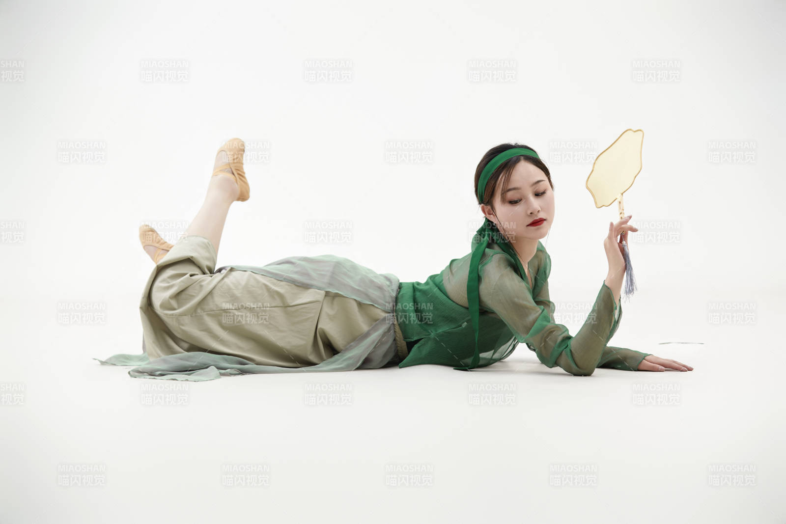 身穿青色古典舞蹈服裝手拿蒲扇跳舞的少女