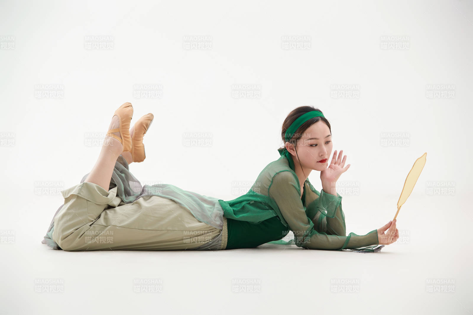 身穿青色古典舞蹈服裝手拿蒲扇跳舞的少女