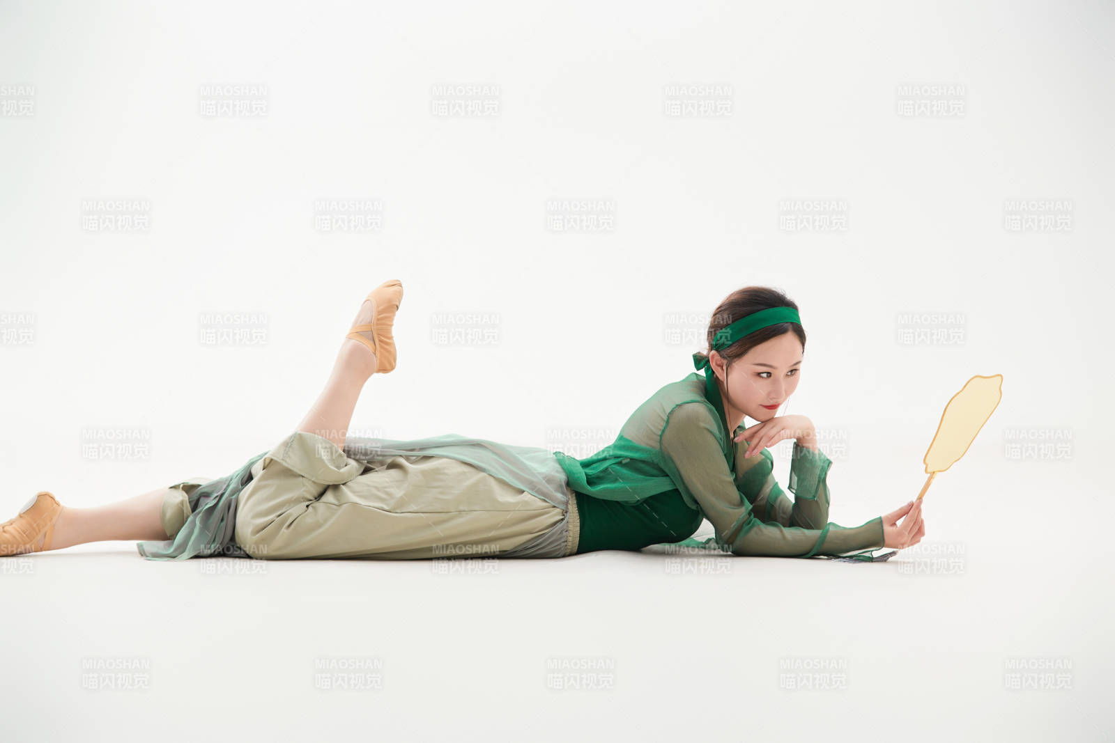 身穿青色古典舞蹈服裝手拿蒲扇跳舞的少女